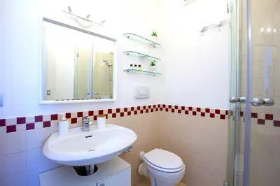 a bathroom with a sink and a toilet and a mirror at Hostly - Family Home Stresa in Rome