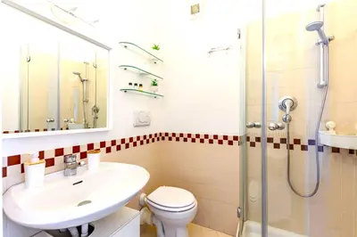 a bathroom with a sink toilet and a shower at Hostly - Family Home Stresa in Rome