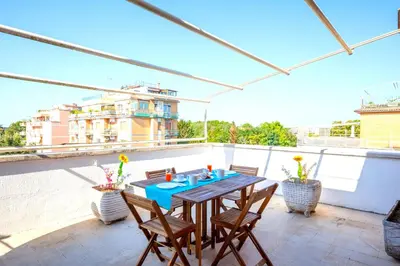 a patio with a table and chairs on a balcony at Hostly - Family Home Stresa in Rome
