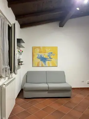 a couch in a living room with a painting on the wall at Residenza niutta- roma in Rome