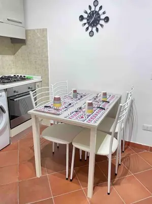 a kitchen with a table with chairs and a stove at Residenza niutta- roma in Rome