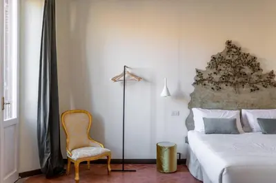 a bedroom with a bed and a chair at iFlat Trevi Fountain's roomy&friendly apartment in Rome