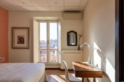 a bedroom with a bed and a desk and a window at iFlat Trevi Fountain's roomy&friendly apartment in Rome