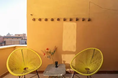 two yellow chairs and a table on a balcony at iFlat Trevi Fountain's roomy&friendly apartment in Rome