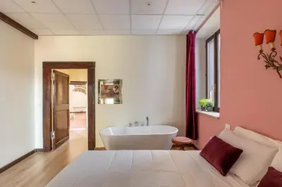 a bedroom with a large bed and a bath tub at iFlat Trevi Fountain's roomy&friendly apartment in Rome
