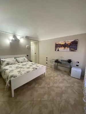 a bedroom with a white bed and a desk at ROMA PARADISO GUEST HOUSE in Rome