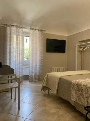 a bedroom with a bed and a television and a window at ROMA PARADISO GUEST HOUSE in Rome
