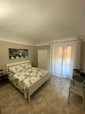 a bedroom with a bed and a table and a window at ROMA PARADISO GUEST HOUSE in Rome