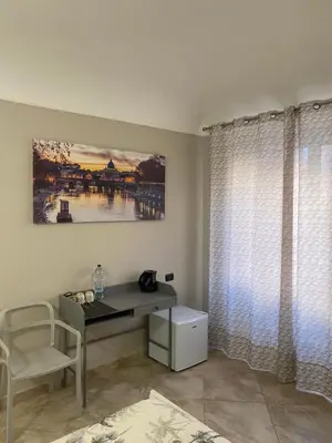 a desk and chair in a room with a window at ROMA PARADISO GUEST HOUSE in Rome