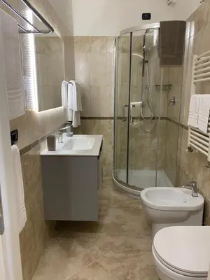 a bathroom with a shower and a toilet and a sink at ROMA PARADISO GUEST HOUSE in Rome