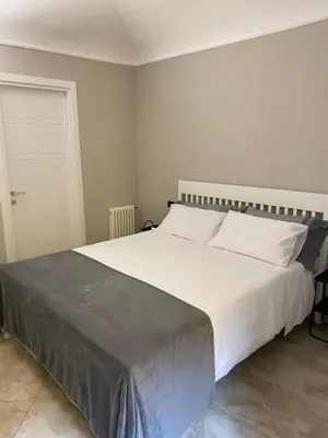 a bedroom with a large bed with white sheets at ROMA PARADISO GUEST HOUSE in Rome