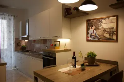a kitchen with a wooden table and a kitchen with white cabinets at A 200Metri Dal Vaticano, 2 Camere Da Letto in Rome