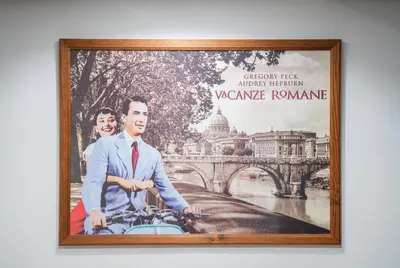 a framed picture of a man on a bike in front of a bridge at A 200Metri Dal Vaticano, 2 Camere Da Letto in Rome