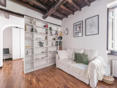 a living room with a white couch and bookshelves at The Best Rent - Elegant apartment in Trastevere in Rome