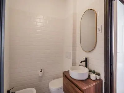 a bathroom with a sink and a toilet and a mirror at The Best Rent - Elegant apartment in Trastevere in Rome