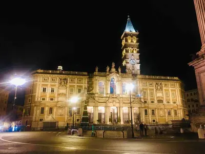 a large building with a clock tower at night at Lovely studio near the Colosseum in Rome