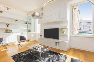 a white living room with a flat screen tv at Amazing Vista Piazza Venezia in Rome