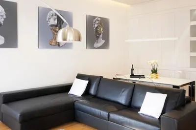 a living room with a black leather couch at Amazing Vista Piazza Venezia in Rome