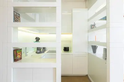 a white kitchen with white cabinets and shelves at Amazing Vista Piazza Venezia in Rome