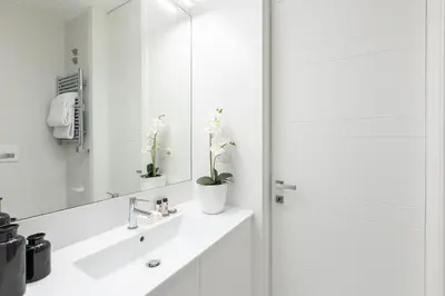 a white bathroom with a sink and a mirror at Amazing Vista Piazza Venezia in Rome