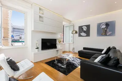 a living room with a black couch and a tv at Amazing Vista Piazza Venezia in Rome