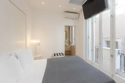 a white bedroom with a bed and a window at Amazing 3 Levels Penthouse Piazza Venezia in Rome