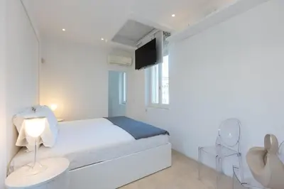 a white bedroom with a bed and a tv at Amazing 3 Levels Penthouse Piazza Venezia in Rome