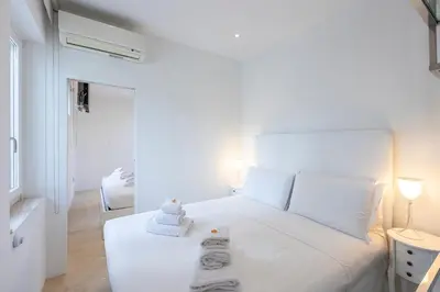 a white bedroom with a white bed with towels on it at Amazing 3 Levels Penthouse Piazza Venezia in Rome