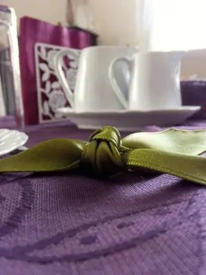 a green bow on a purple table with cups at L'Appartamento Romano in Rome