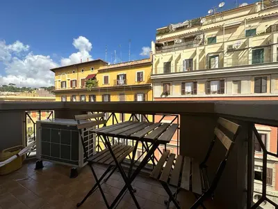 a table and chairs on a balcony with buildings at La CASA DI SABINA in Rome