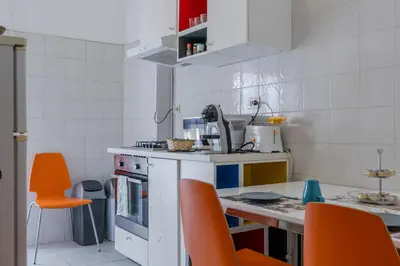 a small kitchen with orange chairs and a counter at La CASA DI SABINA in Rome