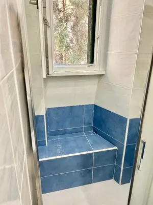 a bathroom with blue tiles and a window at Roma Apartment holiday in Rome