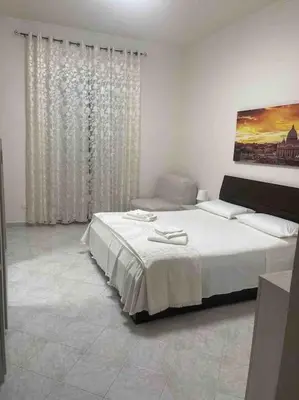 a white bedroom with a bed and a window at Casa vacanze Pigneto Roma in Rome