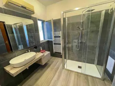 a bathroom with a sink and a glass shower at Casa vacanze Pigneto Roma in Rome