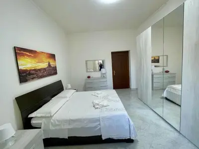 a white bedroom with a large bed and a mirror at Casa vacanze Pigneto Roma in Rome