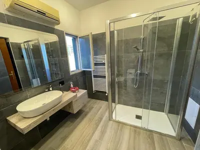 a bathroom with a sink and a glass shower at Casa vacanze Pigneto Roma in Rome