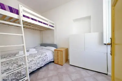 a bedroom with a bunk bed and a refrigerator at Piccola Piazza Della Libertà in Rome