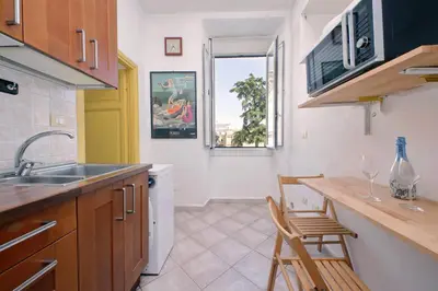 a kitchen with a sink and a counter with chairs at Piccola Piazza Della Libertà in Rome