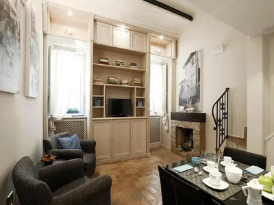 a living room with a table and chairs and a fireplace at Antiche Residenze Romane - CAMPO DE' FIORI in Rome