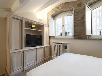 a bedroom with a bed and a tv and windows at Antiche Residenze Romane - CAMPO DE' FIORI in Rome