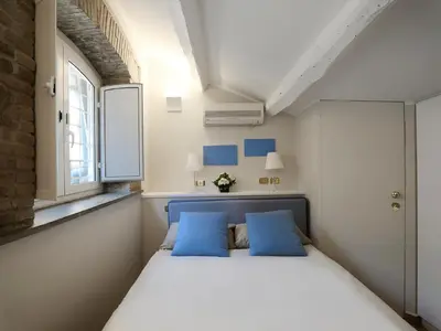a bedroom with a bed with blue pillows and a window at Antiche Residenze Romane - CAMPO DE' FIORI in Rome