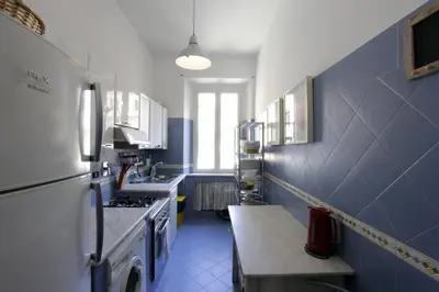 a blue and white kitchen with a sink and a refrigerator at Cattaneo Flat in Rome