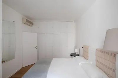 a white bedroom with a bed and a door at Via Francesco Crispi Private Apartment in Rome