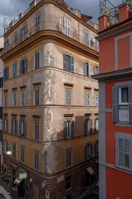 an old building with a balcony on the side of it at Via Francesco Crispi Private Apartment in Rome
