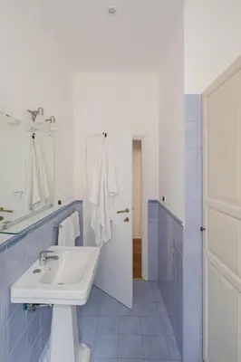 a blue and white bathroom with a sink and a mirror at Via Francesco Crispi Private Apartment in Rome