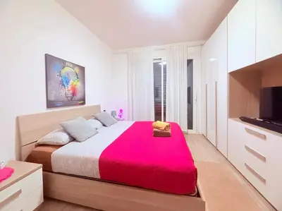 a bedroom with a large bed with a red blanket at Pandora apartments in Rome