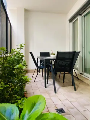 a patio with black chairs and a table and some plants at Pandora apartments in Rome