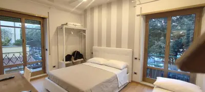 a bedroom with a bed and a balcony with windows at Portonaccio suite - Stazione Tiburtina - Università - Metro B in Rome