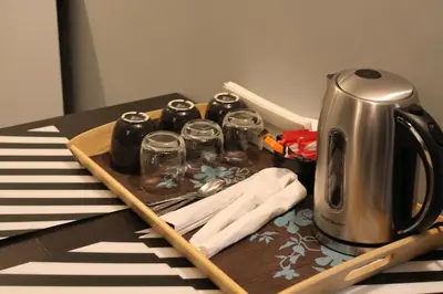 a table with a tray with a coffee pot and glasses at Relais Arco Della Pace in Rome
