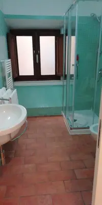 a bathroom with a glass shower and a sink at Relais Arco Della Pace in Rome